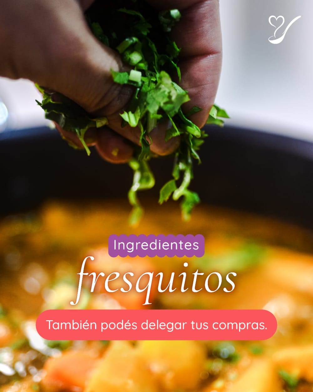 Mano agregando hierbas frescas a una olla en la cocina